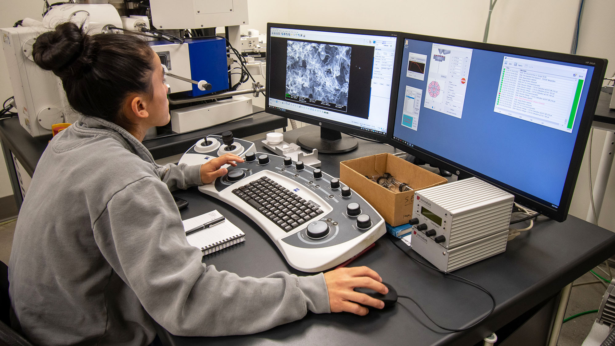 Anna Klug works on lab equipment with multiple monitors.